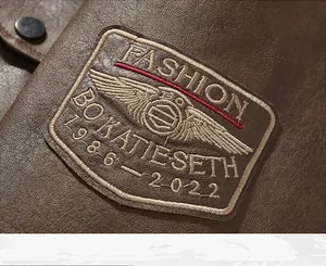 Close-up of vintage embroidered patch on brown faux leather motorcycle jacket sleeve