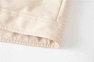 Detail of double-stitching on the hem of a premium beige PU leather motor jacket