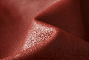 Macro shot of high-quality burgundy PU leather texture with detailed pebble grain pattern