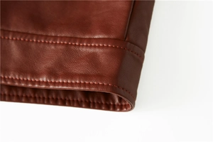 Close-up of the brown leather jacket sleeve showing neat stitching and premium texture