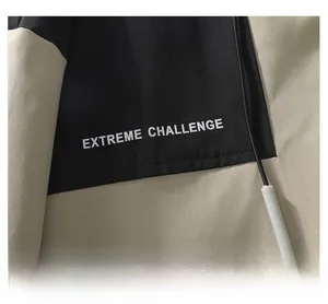 Detail of outdoor jacket showing stitching and Extreme Challenge print in black and khaki