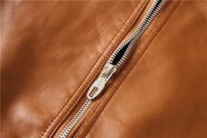 Close-up of metal zipper and fine grain texture on caramel brown leather biker jacket