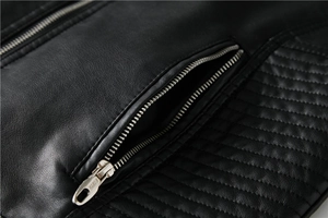 Detail of metal zipper pocket and quilted texture on a black faux leather biker jacket