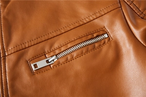 Close-up of caramel brown PU leather jacket showing zipper and grain texture detail