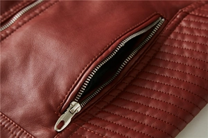 Detail shot of the side zipper pocket and horizontal quilting on burgundy faux leather jacket