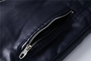 Detailaufnahme einer dunkelblauen Lederjacke mit hochwertigem Metallreißverschluss