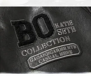 Close-up of black PU leather jacket featuring intricate silver embroidery and letter patches