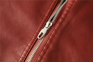 Detailaufnahme einer roten PU-Lederjacke mit Metallreißverschluss und feinen Nähten