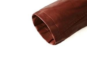 Detail of dark red faux leather jacket sleeve with reinforced double stitching accents