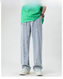 Detail of light blue wide-leg jeans featuring front center seams and adjustable drawstring waist
