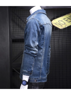 Detailed close-up of heavy-wash denim jacket sleeve with vintage whiskers and metal grid
