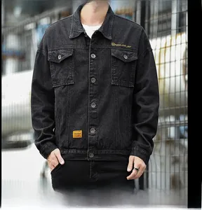Dettaglio della giacca di jeans lavata nera con ricamo giallo e tasche in stile utilitario