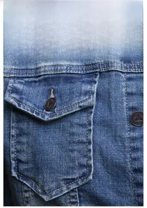 Close-up of blue washed denim jacket detail showing brass buttons with embossed text