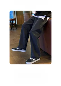Détail d'un jean rétro délavé foncé, coupe droite et large pour homme avec chaussures en toile