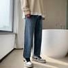 Detail of loose-fit retro blue straight-leg jeans with washed denim texture and wide leg style