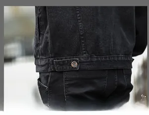Dettaglio dell'orlo della giacca di jeans nera con linguette regolabili e bottoni in metallo