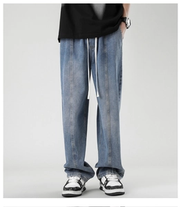 Close-up of light blue vintage wash jeans with drawstring waist and vertical pleat detail