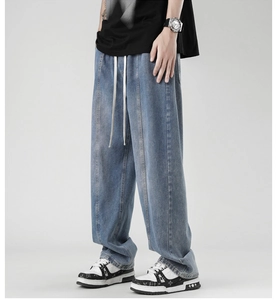 Detail view of light blue wide-leg jeans with elastic drawstring waist and vertical seam lines