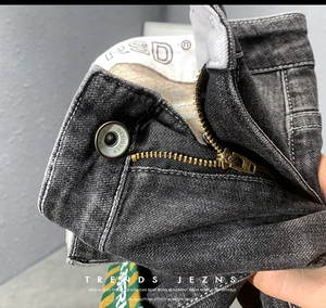 Gros plan détaillé de la fermeture éclair en métal, du bouton design et de la taille stretch