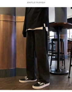 Gros plan sur le jean noir délavé vintage pour homme dans un décor de café chic