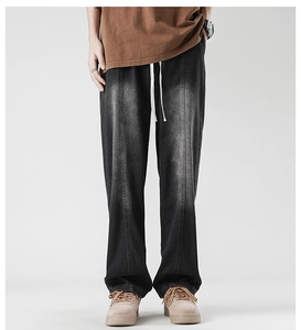 Detail of grey washed denim jeans with elastic drawstring waist and vertical stitching