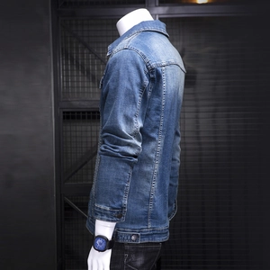 Slim fit men's blue washed denim jacket with lapel collar and industrial metal background