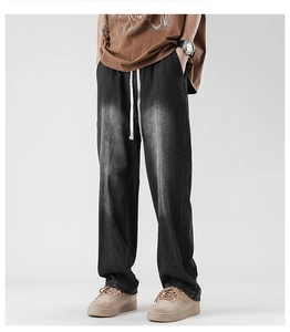 Detail of grey washed straight-leg jeans with elastic drawstring waist and whiskering