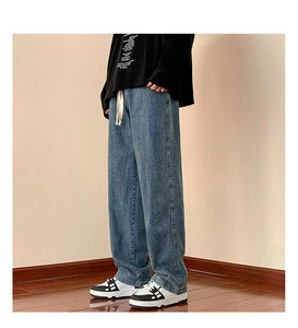Detail of light blue wide-leg jeans with washed texture and white drawstring waist