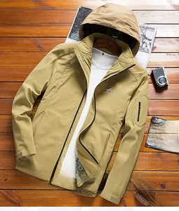 Detail of khaki outdoor hooded jacket featuring functional sleeve pocket and mountain logo