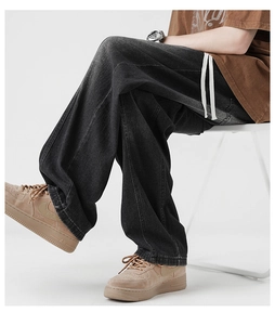 Detail view of baggy denim pants showing the waist drawstring and washed fabric texture