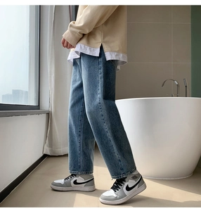 Side view of light blue washed denim jeans featuring straight-cut fit and heavy wash texture