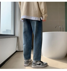 Detail view of the back drape and retro washed blue finish on men's wide-leg jeans
