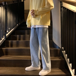 Jean homme bleu clair délavé coupe large décontractée sur un escalier en bois