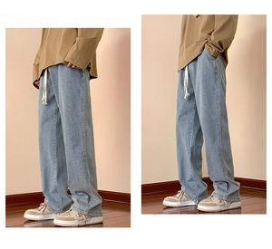 Detail of light blue wide leg jeans featuring an elastic waist with white drawstring