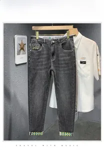 Détail d'un jean gris coupe droite avec écussons décoratifs et marquage à la taille