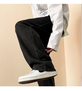 Detailed shot of men's black baggy denim jeans with white sneakers in street style
