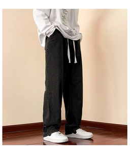 Detail view of black wide-leg trousers featuring adjustable white drawstring waist
