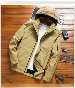 Detail of khaki hooded outdoor jacket with chest embroidery on vintage wood background