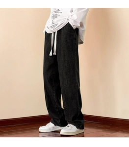 Detail view of washed black wide-leg jeans with a thick white contrast drawstring waist