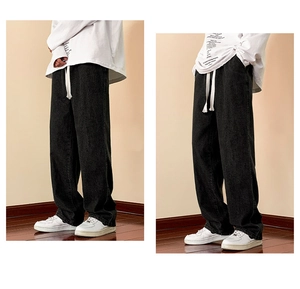 Detail of loose fit dark grey men's straight leg trousers with white drawstring waist