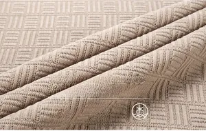 Gros plan sur un tricot en chenille épais avec une texture géométrique beige chaud