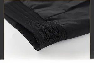 Detail of black woven jacket hem featuring tight ribbed knit cuffs and fine stitching