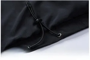 Macro shot of the adjustable drawstring hem with toggle on the black jacket