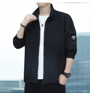 Detail of black sporty outdoor jacket featuring zip-up stand collar and arm sleeve patch