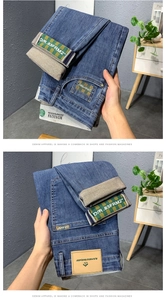 Détail macro du jean bleu pour hommes montrant la bande écossaise et le patch en cuir