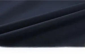 Close-up of high-density navy blue textile fabric showing fine weave and smooth texture