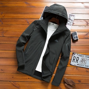 Dark grey hooded outdoor jacket with windproof fabric and arm pocket on wood background