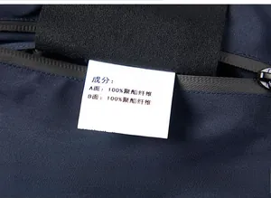 Detail of a black zipper and white fabric care label on a navy blue polyester jacket