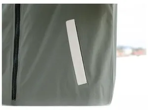 Detail of olive green hooded jacket featuring pocket display and black zipper closure