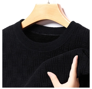 Détail du pull en chenille noire épaisse avec texture gaufrée et col rond doux